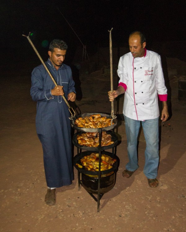 Bedouin cooks bring out food at the Wadi Rum Overnight Luxury Camp