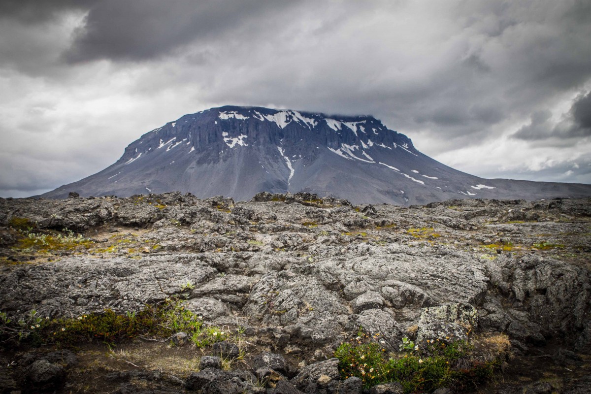 Herdubreid mountain in the Icelandic Highlands is capped with snow amidst it's desolate surroundings.